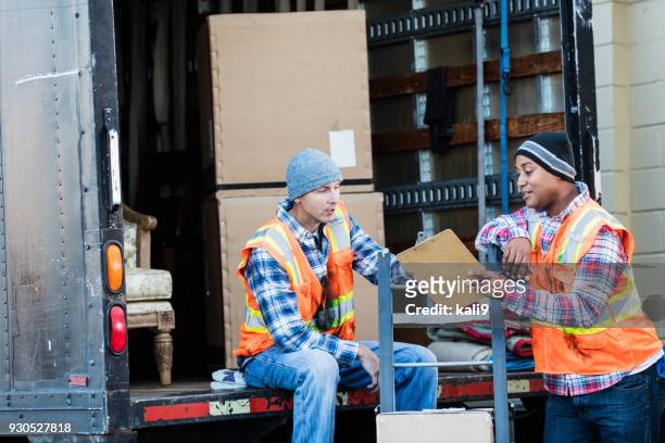 two workers with a truck, moving furniture, boxes - loader reading stock pictures, royalty-free photos & images