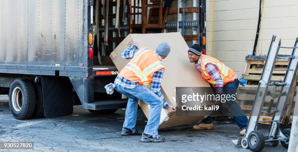 due operai con un camion, in movimento grande scatola - sollevare foto e immagini stock