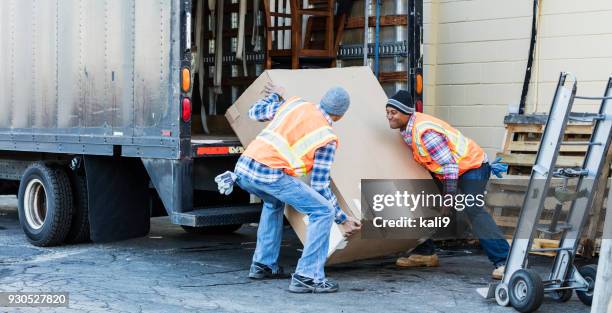 two workers with a truck, moving large box - retrieving stock pictures, royalty-free photos & images