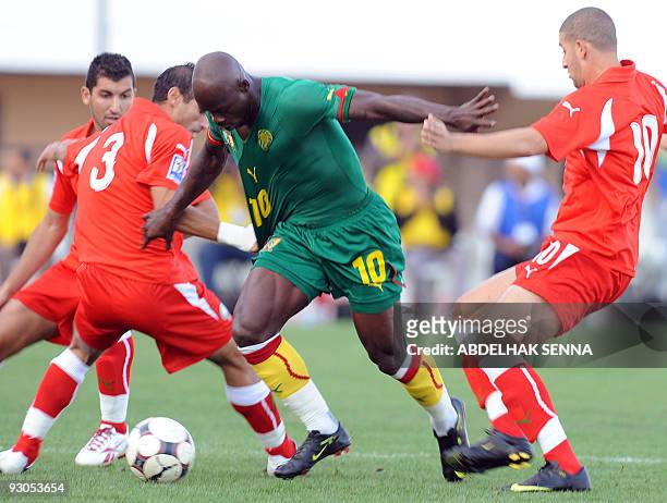 Cameroon's Achille Emana fights for the ball with Morocco's Zakaria Zerouali and Adel Taarabt during their Fifa 2010 World Cup play off match on...