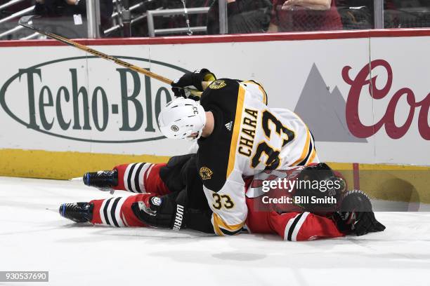 Zdeno Chara of the Boston Bruins lays on top of Brandon Saad of the Chicago Blackhawks in the third period at the United Center on March 11, 2018 in...