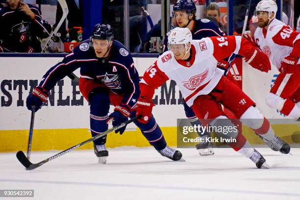 Jack Johnson of the Columbus Blue Jackets and Gustav Nyquist of the Detroit Red Wings chase after the puck during the game on March 9, 2018 at...
