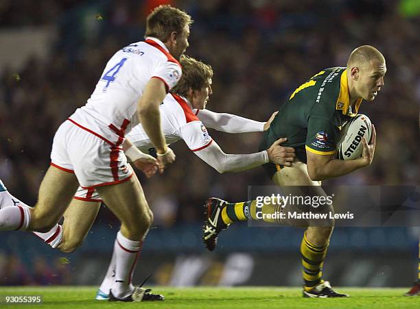 Luke Lewis of Australia is tackled by Sam Tomkins of England during the Four Nations Grand Final between England and Australia at Elland Road on...