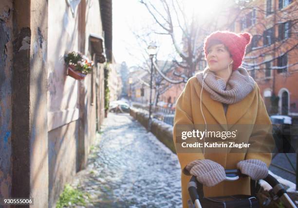 woman with baby stroller in wintery rome, ground covered with snow - femme poussette rue photos et images de collection