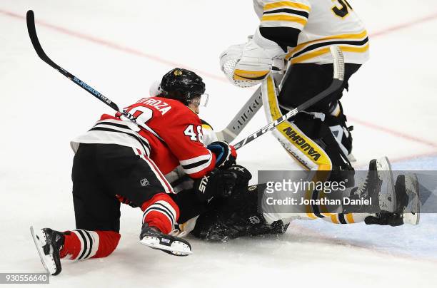 Vinnie Hinostroza of the Chicago Blackhawks collides with Adam McQuaid of the Boston Bruins near the crease at the United Center on March 11, 2018 in...