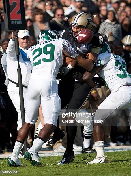 Keith Smith of the Purdue Boilermakers fumbles the ball following a reception and being hit by Michigan State Spartan defenders at Ross-Ade Stadium...
