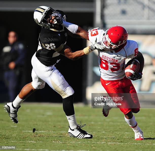 Cornerback Josh Robinson of the Central Florida Knights and Wide receiver Patrick Edwards of the Houston Cougars battle following a pass reception,...