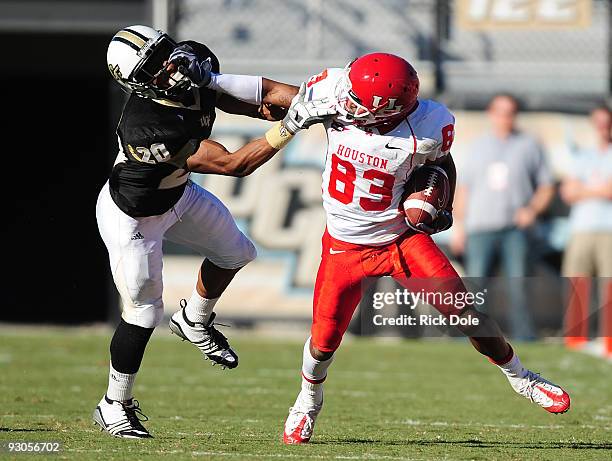 Cornerback Josh Robinson of the Central Florida Knights and Wide receiver Patrick Edwards of the Houston Cougars battle following a pass reception,...