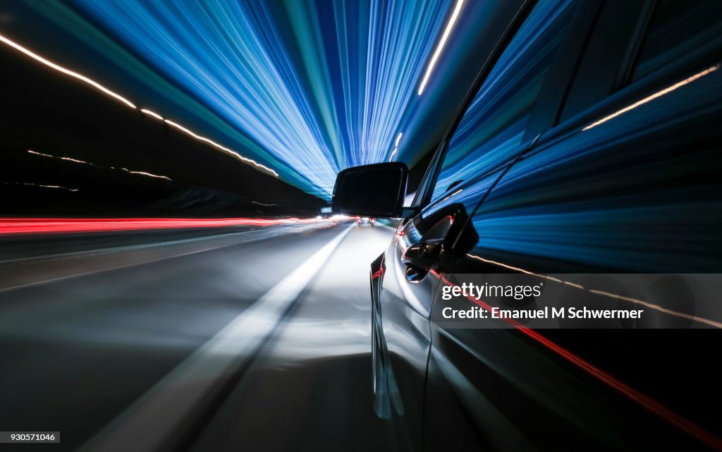 Black German car drives fast on Autobahn