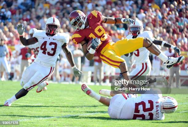 Brice Butler of the USC Trojans is tackled by Bo McNally and Chike Amajoyi of the Stanford Cardinal during the first half at the Los Angeles Memorial...