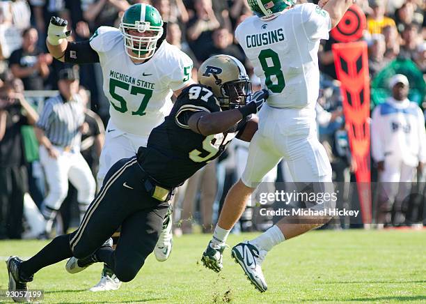 Gerald Gooden of the Purdue Boilermakers puts a hit on quarterback Kirk Cousins of the Michigan State Spartans as he gets a pass off at Ross-Ade...