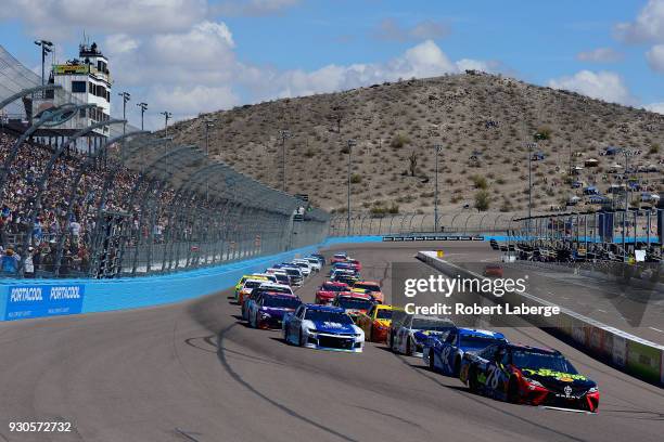 Martin Truex Jr., driver of the 5-hour Energy/Bass Pro Shops Toyota, leads the field past the green flag to start the Monster Energy NASCAR Cup...