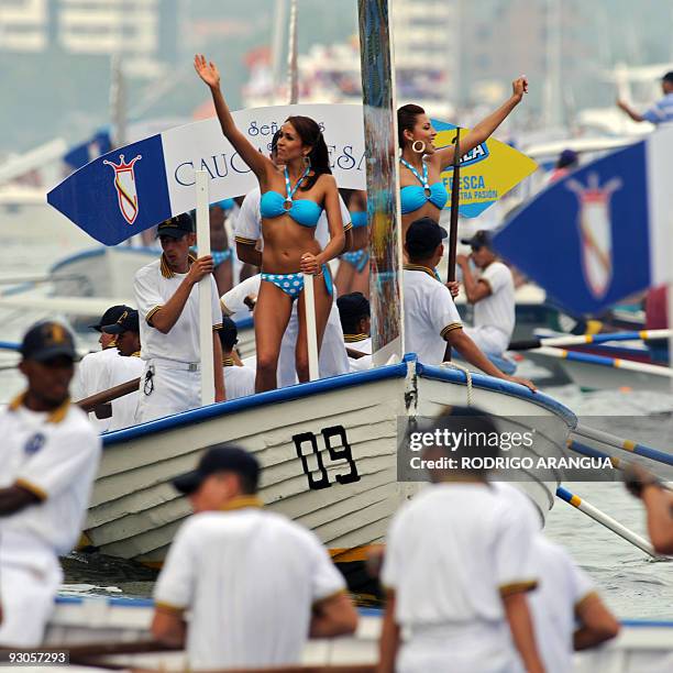 Cauca department's contestant Karen Mamian Fernandez and Cesar department's contestant Sara Ordonez wave during the "Desfile en Balleneras" in...