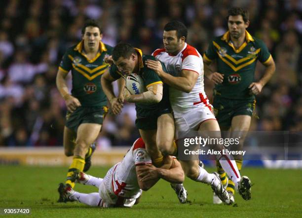 Paul Gallen of Australia is tackled by Sam Burgess and Chris Bridge of England during the Four Nations Grand Final at Elland Road on November 14,...