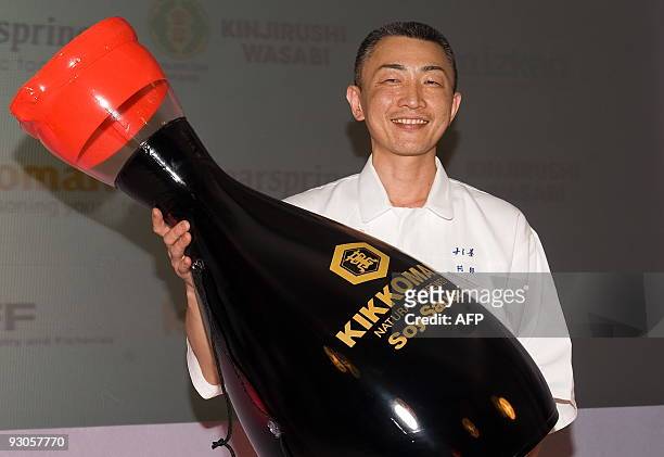Winner of the "Seven Sushi Samurai" Sushi of the Year awards 2009 Tomoyuki Abe from Japan poses with an inflateable soy sauce bottle at the Olympia...