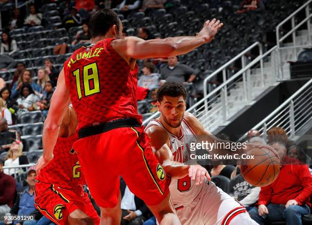 Zach LaVine of the Chicago Bulls drives against Tyler Dorsey and Miles Plumlee of the Atlanta Hawks at Philips Arena on March 11, 2018 in Atlanta,...