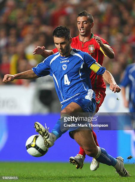 Simao Sabrosa of Portugal tangles with Emir Spahic of Bosnia during the FIFA 2010 European World Cup qualifier first leg match between Portugal and...