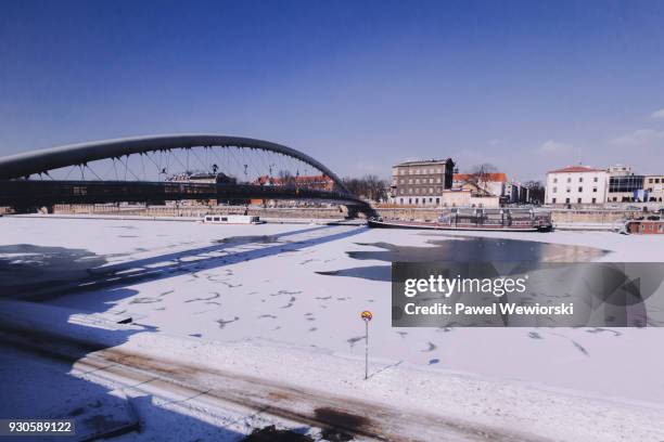 foot bridge over frozen river - cieszyn stock-fotos und bilder