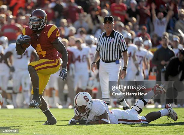 Joe McKnight of the USC Trojans eludes the diving tackle from Delano Howell of the Stanford Cardinal to score a touchdown during the second half at...