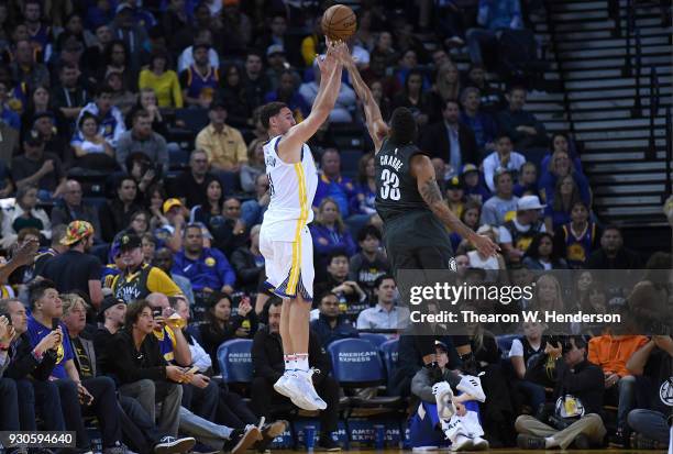 Klay Thompson of the Golden State Warriors shoots over Allen Crabbe of the Brooklyn Nets during an NBA basketball game at ORACLE Arena on March 6,...