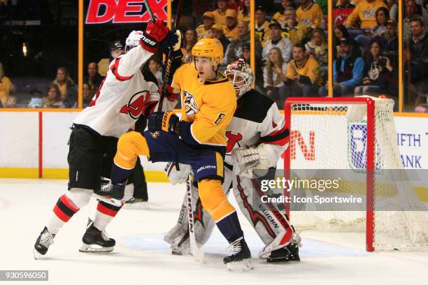 Nashville Predators center Kyle Turris and New Jersey Devils defenseman Damon Severson battle for position in front of New Jersey Devils goalie Keith...