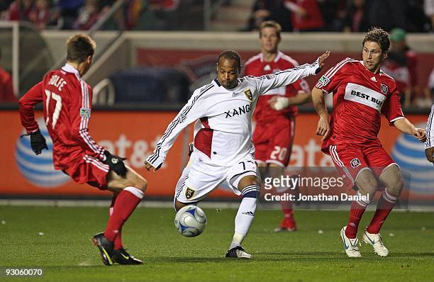 Andy Williams of Real Salt Lake passes the ball between Chris Rolfe and Logan Pause of the Chicago Fire during the MLS Eastern Conference...