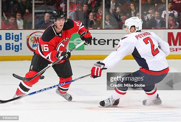 Matt Halischuk of the New Jersey Devils flips the puck over the outstretched stick of Brian Pothier of the Washington Capitals at the Prudential...