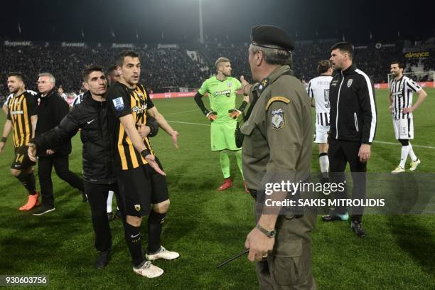 Policeman orders AEK defender Vassilis Lampropoulos and other players to leave the pitch, during incidents following the referee's decision to...