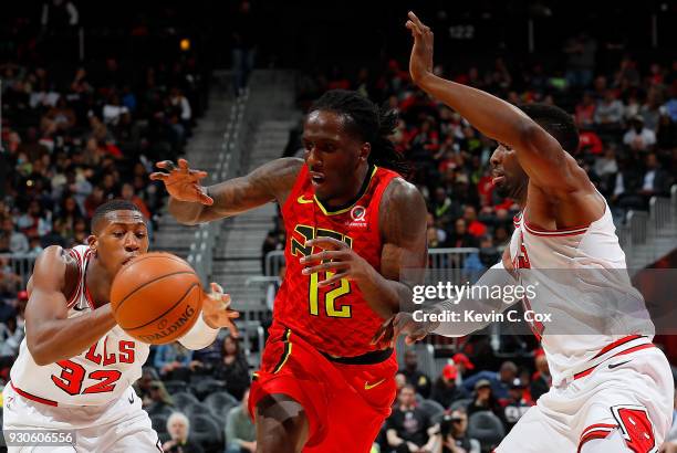 Kris Dunn of the Chicago Bulls attempts a steal as Taurean Prince of the Atlanta Hawks drives against David Nwaba at Philips Arena on March 11, 2018...