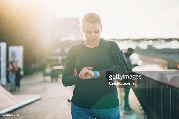 sportswoman looking at her smart watch - checking sports stock pictures, royalty-free photos & images