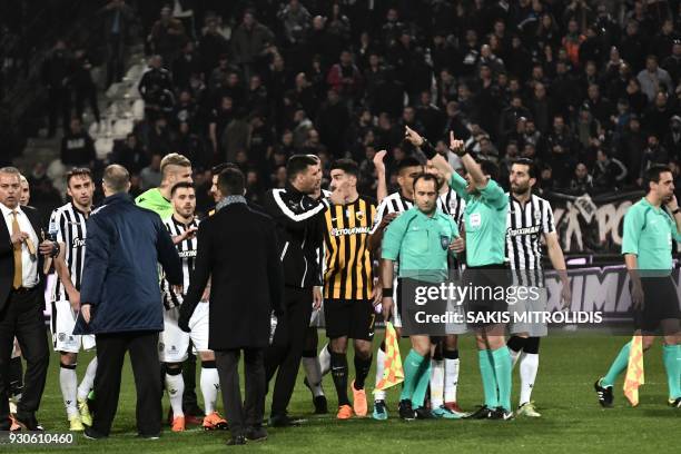Referees and players stand in confusion on the pitch, during incidents following the referee's decision to disallow PAOK an injury-time goal on March...