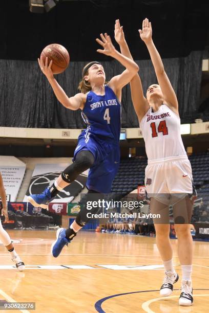 Kerri McMahan of the Saint Louis Billikens drives to the basket by Eniko Kuttor of the Duquesne Lady Dukes during the quarterfinal round of the...