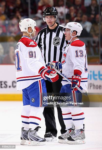 Scott Gomez and Mike Cammalleri of the Montreal Canadiens talk with linesman Shane Heyer during the NHL game against the Phoenix Coyotes at...