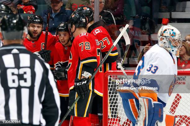 Johnny Gaudreau, Micheal Ferland and teammates of the Calgary Flames skates celebrate a goal against the New York Islanders during an NHL game on...