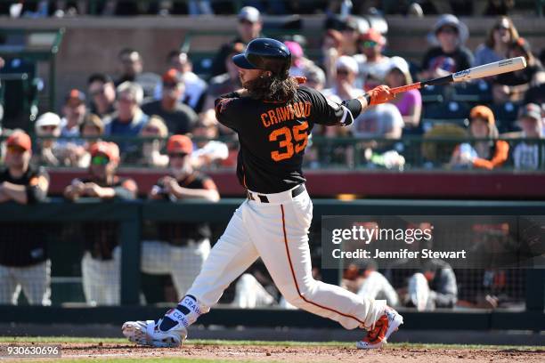 Brandon Crawford of the San Francisco Giants swings at a pitch in the spring training game against the Kansas City Royals at Scottsdale Stadium on...