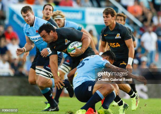 Agustin Creevy of Jaguares is tackled by Israel Folau of Waratahs during a match between Jaguares and Waratahs as part of fourth round of Super Rugby...