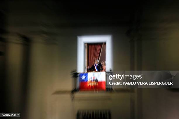 Chilean President Sebastian Pinera speaks next to his wife Cecilia Morel from the balcony at La Moneda presidential palace in Santiago on 11 March,...