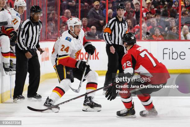 Thomas Chabot of the Ottawa Senators defends against Travis Hamonic of the Calgary Flames at Canadian Tire Centre on March 9, 2018 in Ottawa,...