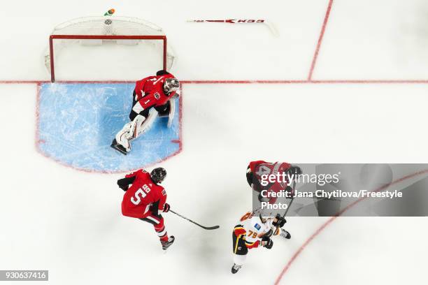 Having lost his stick, Mike Condon of the Ottawa Senators along with teammates Cody Ceci and Mark Borowiecki defend against Micheal Ferland of the...