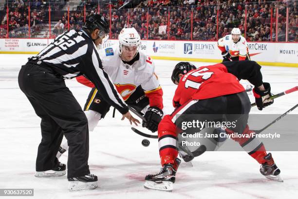 Lineman Shandor Alphonso drops the puck for a face-off between Mark Jankowski of the Calgary Flames and the Zack Smith of the Ottawa Senators at...