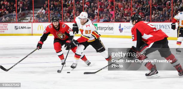 Zack Smith and Cody Ceci of the Ottawa Senators defend against a puck carrying Sam Bennett of the Calgary Flames at Canadian Tire Centre on March 9,...