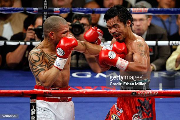 Miguel Cotto of Puerto Rico throws a left to the body of Manny Pacquiao during their WBO welterweight title fight at the MGM Grand Garden Arena on...