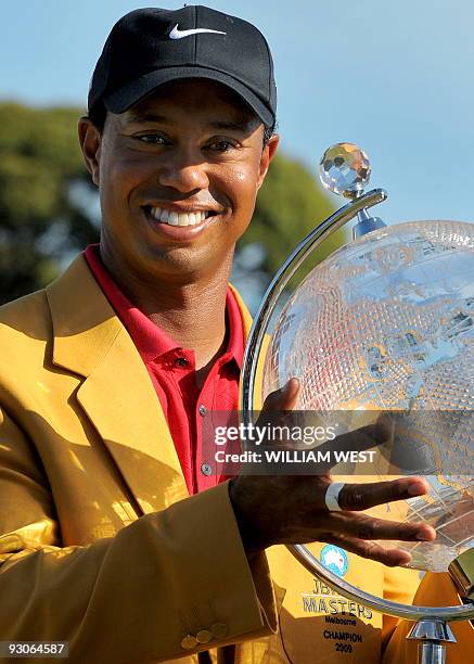 Tiger Woods of the US holds the trophy aloft after winning the Australian Masters golf tournament at the Kingston Heath course in Melbourne on...