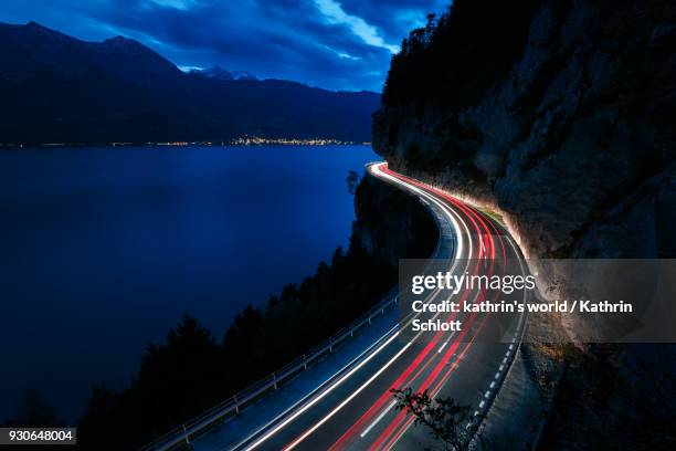 light trails at lake thun - rear light car stock pictures, royalty-free photos & images