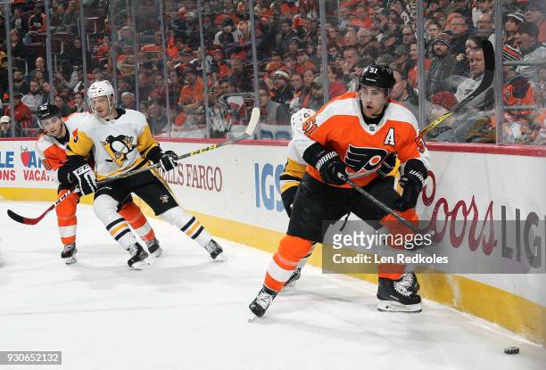 Valtteri Filppula of the Philadelphia Flyers skates the puck along the boards against the Pittsburgh Penguins with Jordan Weal defending Jamie...