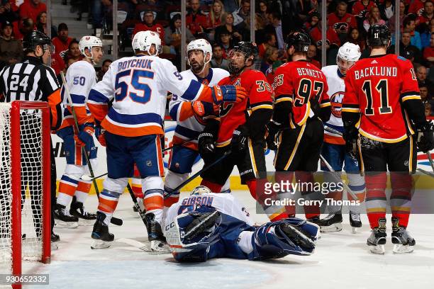Troy Brouwer of the Calgary Flames is pushed by Johnny Boychuk the New York Islanders during an NHL game on March 11, 2018 at the Scotiabank...