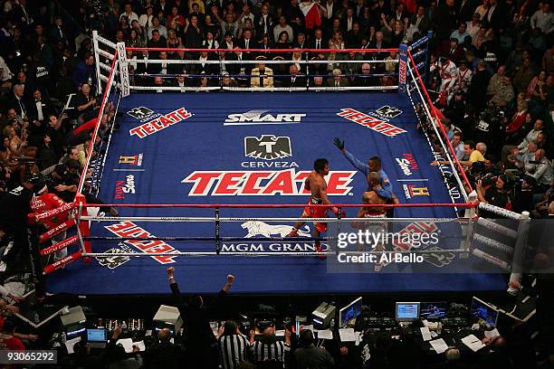 Manny Pacquiao celebrates his 12 round TKO victory against Miguel Cotto as Cotto is consoled by referee Kenny Bayless after their WBO welterweight...