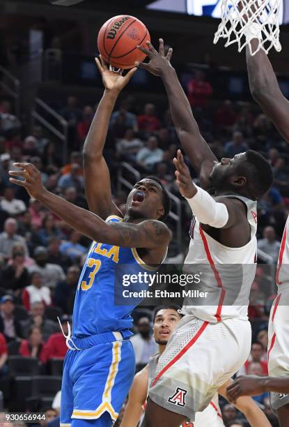 Kris Wilkes of the UCLA Bruins drives to the basket against Rawle Alkins of the Arizona Wildcats during a semifinal game of the Pac-12 basketball...