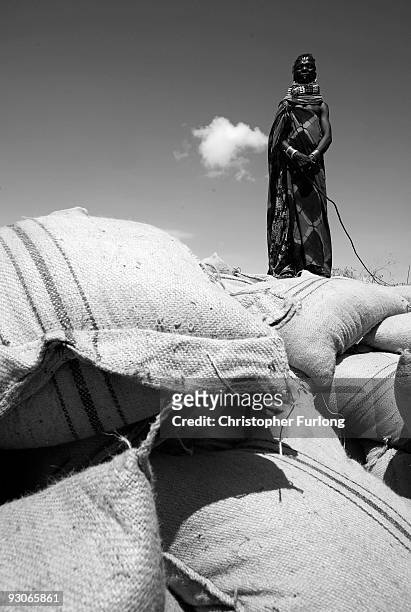 Woman from the remote Turkana tribe in Northern Kenya stands on top of a mound of maize delivered by Oxfam. The villagers themselves decide which...