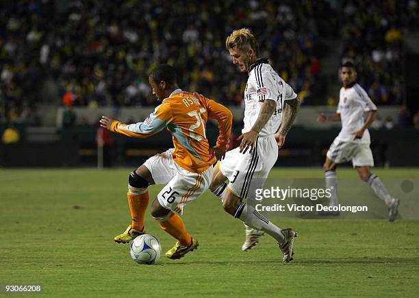 Corey Ashe of the Houston Dynamo looks to play the ball under pressure from David Beckham of the Los Angeles Galaxy during the MLS Western Conference...